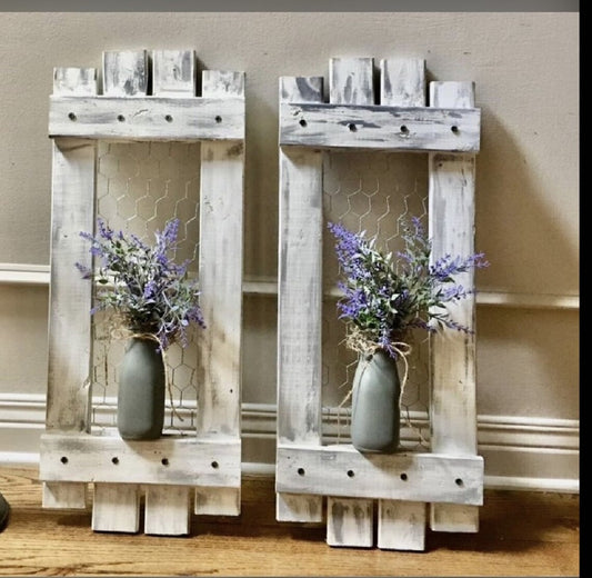 Two wooden wall shelves with floral arrangements on a neutral background