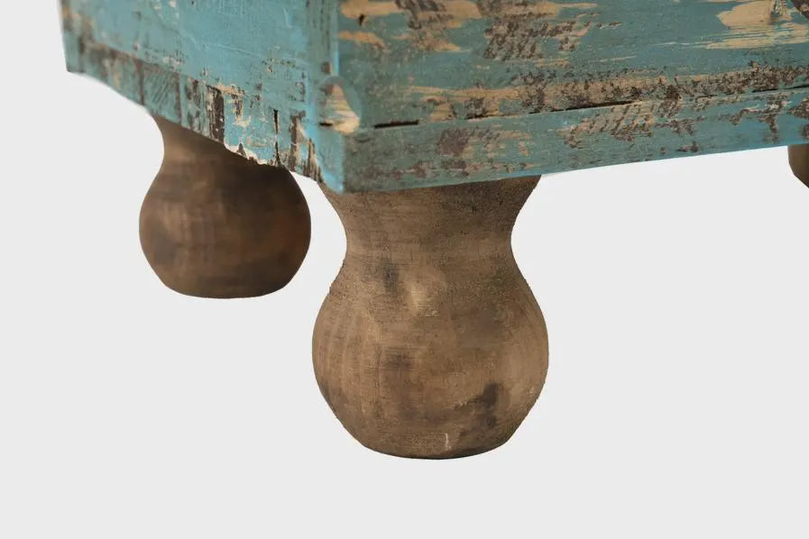 Close-up of a wooden planter box with distressed finish and round legs on a white background