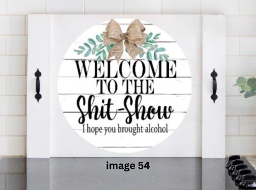 Pink Platypus Emporium funny farmhouse stove cover with Welcome to the Shit Show quote, greenery and rustic bow on solid wood noodle board.